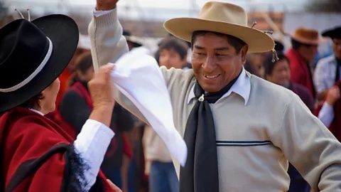 Traditional folk dancers in wide-brimmed hats performing outdoors
