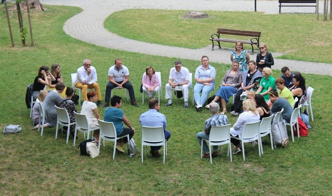 People seated in a circle outdoors during a group gathering
